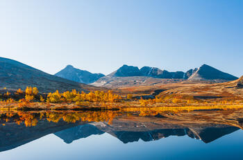 Refleksjon/speilbilde av fjell i Rondane i en liten innsjø.